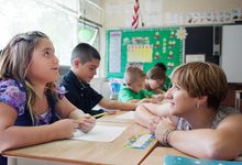 Elementary school teacher speaks to student in classroom
