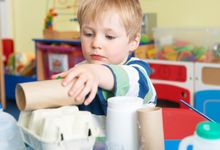 Preschooler plays with household items in class