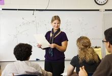 High school math teacher at white board in class. 