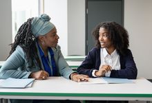 Teacher speaking with student in classroom