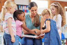 Preschool teacher reads a book to her students