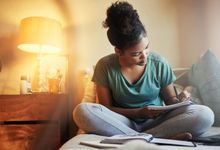 High school student writes at home in her room