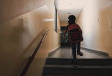 Photo of child running up the stairs in school