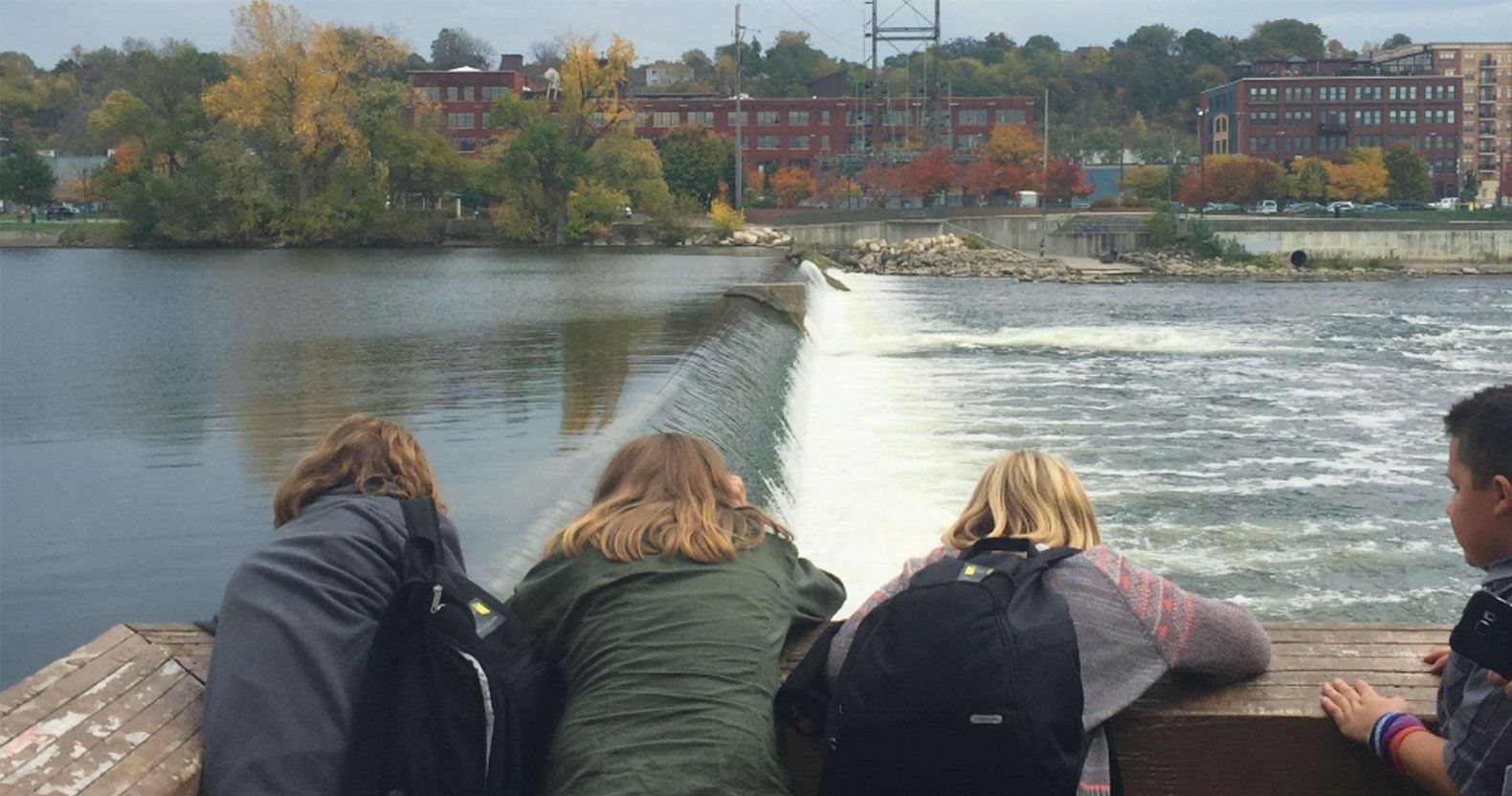 Museum School students look out from a museum balcony over the Grand River, where they learn about freshwater ecosystems and partake in river restoration work.