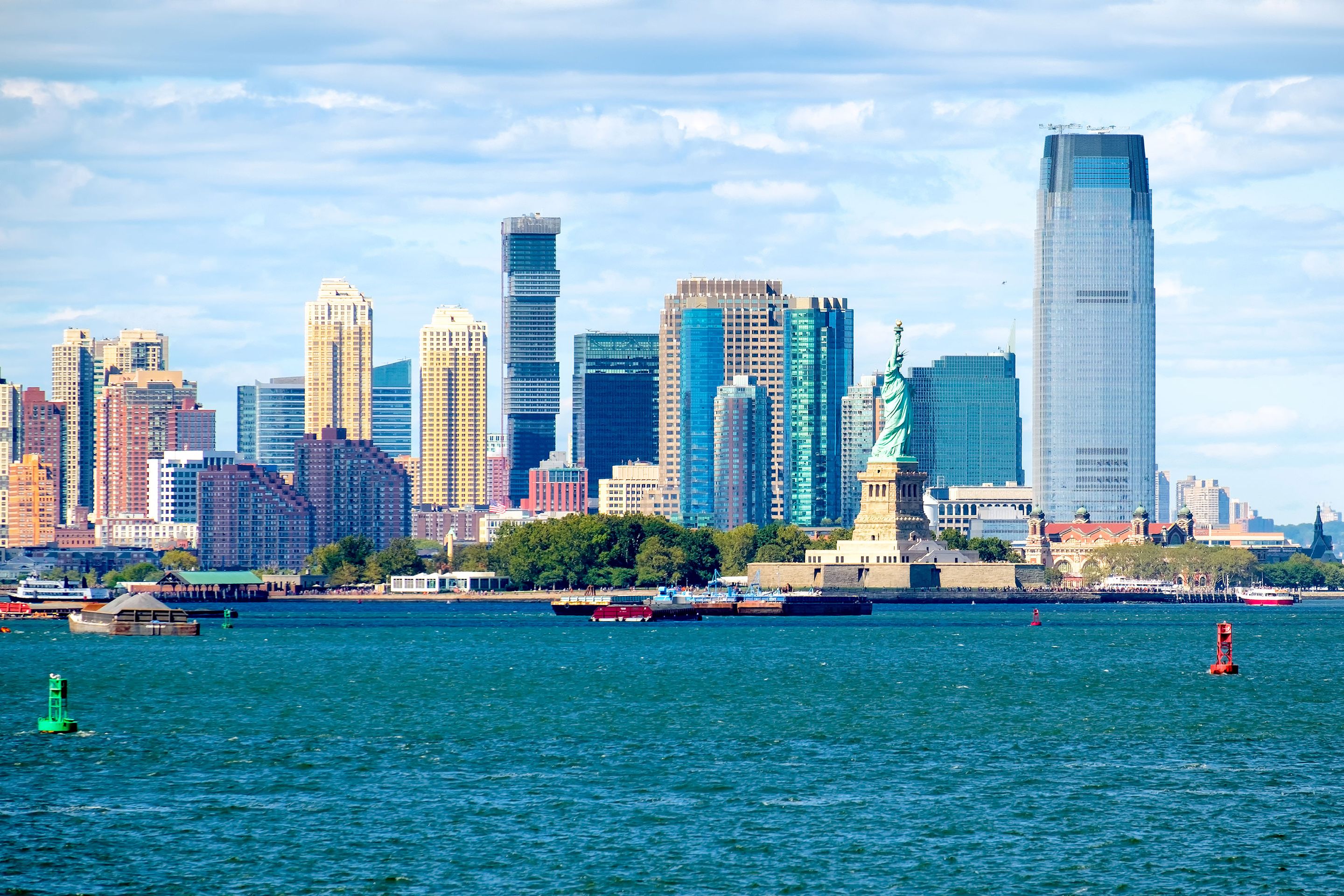 The Jersey City skyline looms behind the Statue of Liberty and Ellis Island. Located right outside New York City, Jersey City has a growing community of refugees from Syria.
