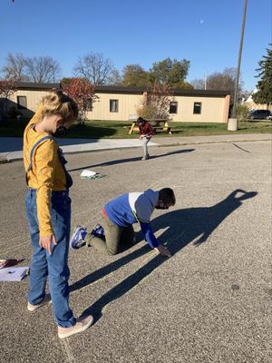 Elementary students conduct a shadow experiment outside