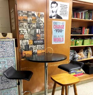 靠在教室墙上的带有凳子的站立式桌子