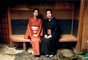 Two beautiful women sitting on a bench in Kyoto
