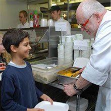 A photo of chef Robert "Bobo" talking with a young student.