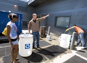 Teacher and student outside with water recycling bins