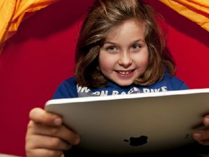 A young girl absorbed in her tablet