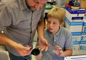 Teacher and student examining a piece of printed plastic