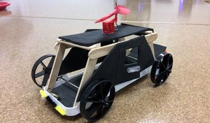 A vehicle created from a plastic tray, foam, and popsicle sticks