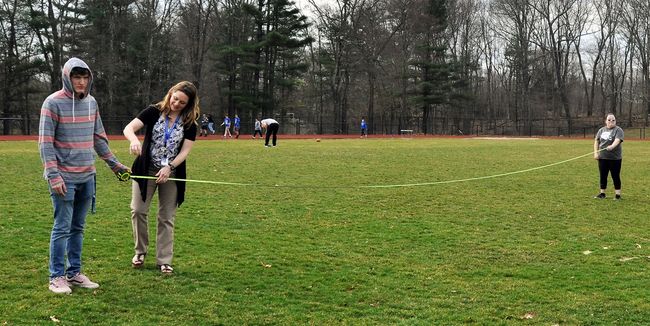 Ashley Swords and her students measure the football field as part of their investigation of the Holocaust through Elie Wiesel’s novel “Night.”